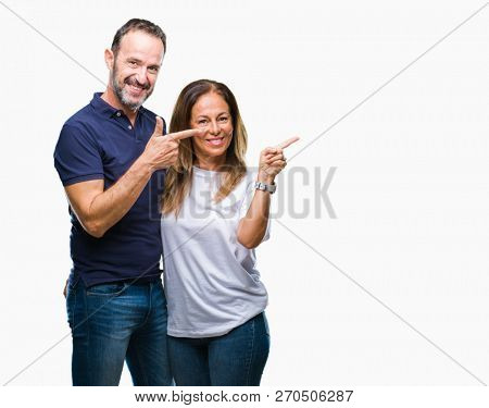 Middle age hispanic casual couple over isolated background smiling and looking at the camera pointing with two hands and fingers to the side.