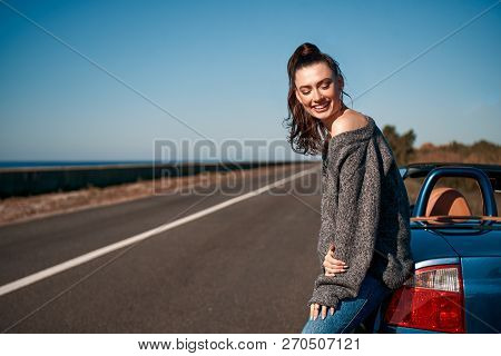 Young Woman With A Tail Standing Near Roofless Car Outdoors