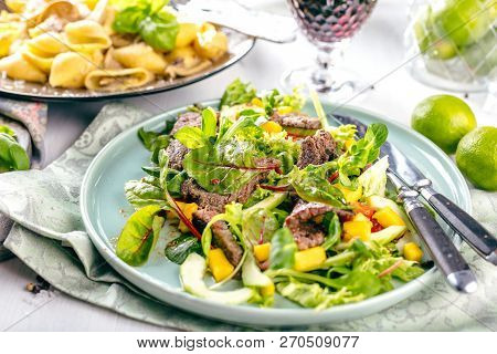 Fresh Salad Plate With Mixed Greens Arugula, Mesclun, Mache On Dark Wooden Background Close Up. Manz