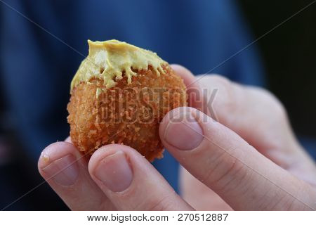 Dutch Snack:  Man Eating A Bitterbal With Mustard. Warm Stuffed Fried Meatballs, Often Served With A