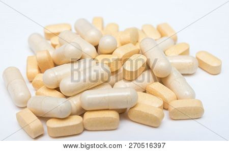 Medicine Yellow Pills Or Capsules On A White Background Close-up. Vitamins Drug Prescription Of Drug