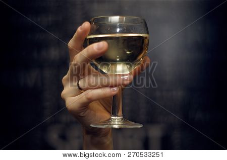 Glass Of Wine In Hand On Dark Background
