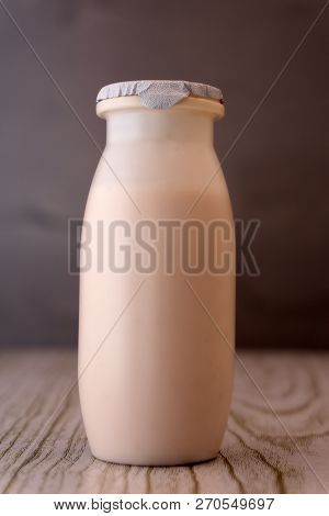 Organic Probiotic Milk Kefir Grains, Tibetan Mushrooms On Wooden Spoon And Kefir Milk In Glass Conta