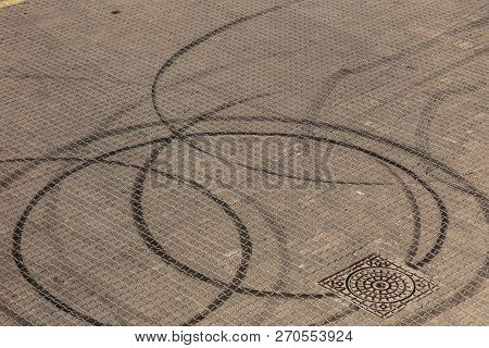 Abstract Transport Background With Pivoting Black Tire Track Over Asphalt Road Surface. Trace Of Dri