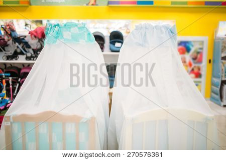 Two wooden baby cots in store, nobody