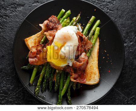 Benedict Poached Duck Egg With Crispy Bacon And Fried Asparagus On Toasts For Breakfast