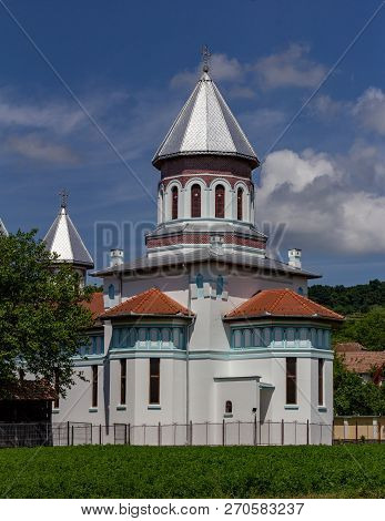 Ornate Orthodox Church In The Village Of Blăjel, Romania Under A Blue Sky