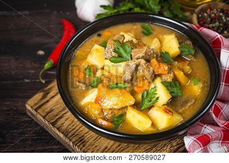 Goulash With Meat And Vegetables In Black Bowl. Beef Stew With Vegetables. European Cuisine.