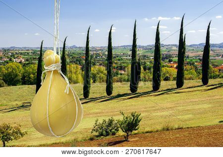 Typical Italian Cheese Caciocavallo Against The Backdrop Of The Characteristic Italian Landscape.