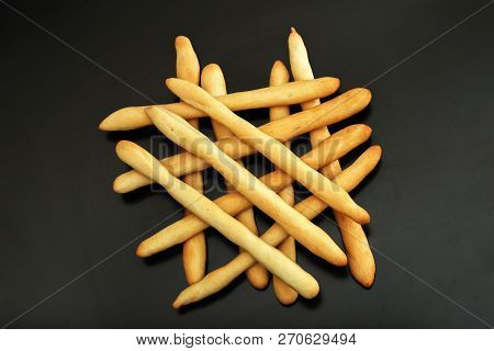 Local Italian Bread, Homemade Breadsticks Grissini On A Black Wooden Table. Baked Italian Grissini C