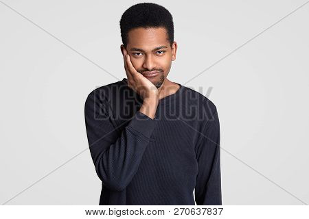 Black Sad Young Man Looks With Dejected Expression, Holds Chin, Has Short Haircut, Dark Skin, Feels 