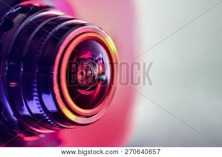 Side View Of The Camera With Red-purple Backlight. Horizontal Photography