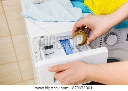 Washing Powder Detergent And Measuring Cup Pouring Into Machine. Household Duties, Clothes Laundry O