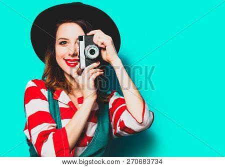 Portrait Of Young Smiling Red-haired White European Woman In Hat And Red Striped Shirt With Camera O
