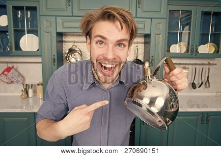 Macho With Happy Face In Blue Shirt Point Finger At Kettle. Kitchen Appliance And Furniture. Food Pr