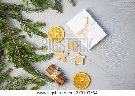 Christmas Tree Pine Brancheswith Present, Orange, Cake, Cinnamon On Grey Background. Toned