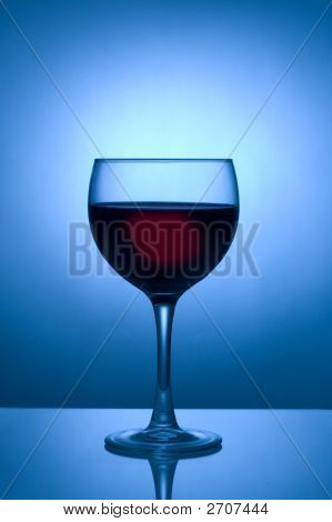 Bicchiere di vino che si staglia contro Spotlight blu