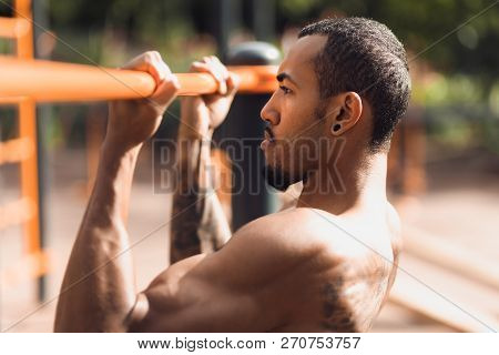 Crossfit Man Doing Pull-ups On Chin-up Bar During Workout Outdoors