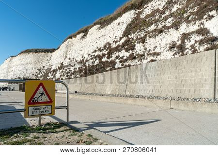 Warning, Danger, Alert Sign Rocks Fall At Saltdean Beach Seafront And White Sandstone Chalk Cliffs.