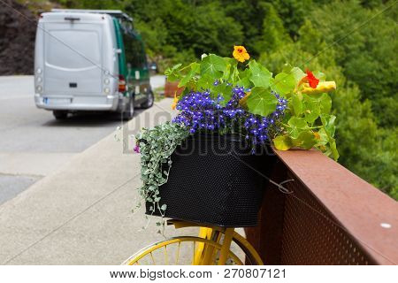 Camper Van With Storage Bag On Parking Area At Svandalsfossen Waterfall In Norway. Flowers Decoratio