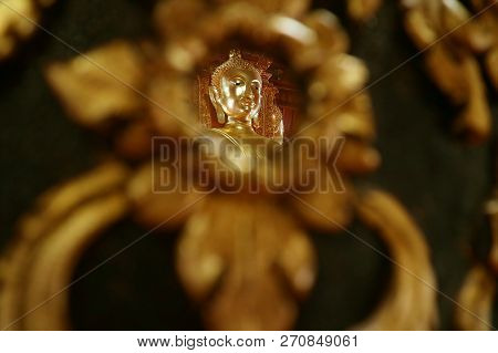 Closed Up The Face Of Golden Buddha Image Reflecting On The Mirror Of Teak Lacquered Pillar In Wat P