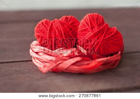 Two Red Hearts From Threads Lie In The Nest. Sweet Romantic Background. Valentines Day Concept. Sele