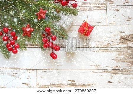 Festive Christmas Background.gift Box With White Bow And Fir Branches With Red Berries And Stars On 