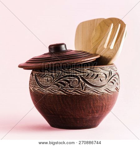 Pots And Plates Of Clay On A White Table And A Pink  Background. Clay Pottery Kitchen Utensils Made