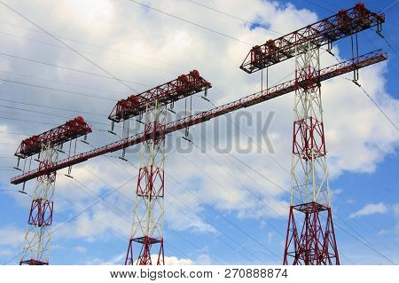 Three Electryc Pylons Against The Cloudy Sky