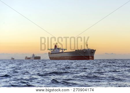 Huge Ships At Sea At Sunset With Orange Sky Bacjground