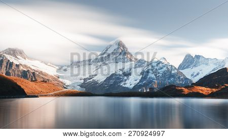 Picturesque view on Bachalpsee lake in Swiss Alps mountains. Snowy peaks of Wetterhorn, Mittelhorn and Rosenhorn on background. Grindelwald valley, Switzerland. Landscape photography