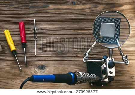 Retro Computer Cpu Chip Through Magnifying Glass Mounted On The Soldering Stand And Soldering Iron O