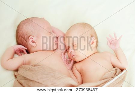 Two Sweet Twins Are Sleeping On The Bed