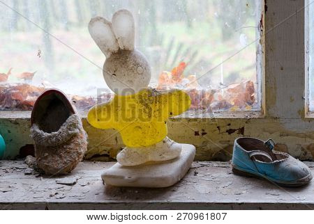 Childrens Plastic Toy And Shoes On Windowsill In Abandoned Kindergarten In Destroyed Village Kopachi