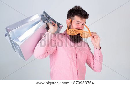 How To Get Ready For Your Next Vacation. Man Bearded Hipster Wear Sunglasses Hold Bunch Shopping Bag