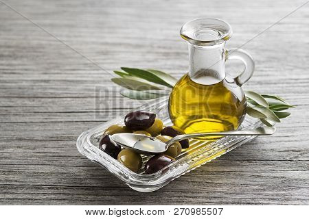 Bottle Of Extra Virgin Healthy Olive Oil With Fresh Olives Close Up