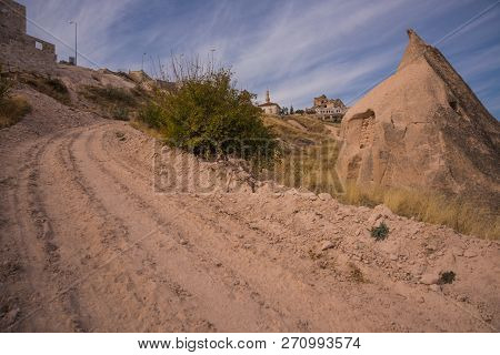 Uchisar, Cappadocia, Turkey: The Road Leads To The City And Uchisar Fortress. Rock Houses And Church