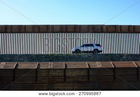 SAN YSIDRO, CALIFORNIA - NOVEMBER 26, 2018: An unmarked  Border patrol vehicle travels along the wall in San Ysidro.
