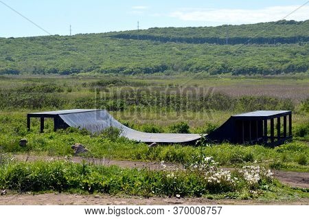 Wooden Halfpipe (skateboard Ramp) Without People On Green Meadow With Blowballs