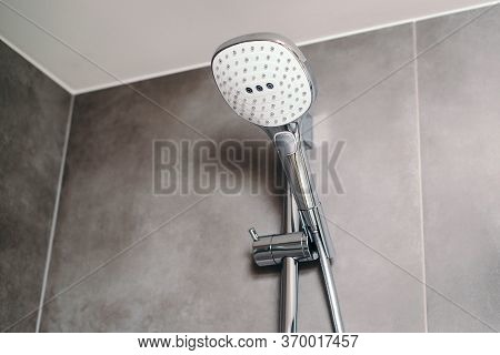 New Head Shower In A Modern Bathroom, Closeup. Shower Head On Grey Modern Wall. Bathroom Shower.