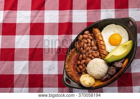 Bandeja Paisa, Typical Dish At The Antioqueña Region Of Colombia. It Consists Of Chicharrón (fried P