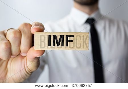 Imf Inscription On A Wooden Block In The Hand Of A Young Businessman In The Office.