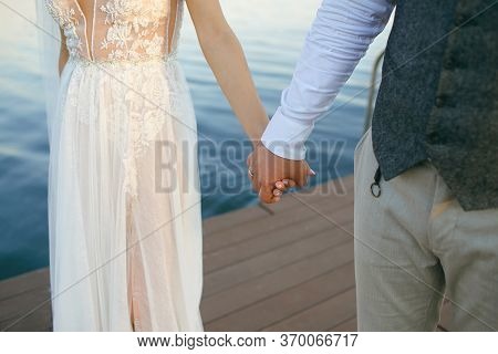 Just Married Couple Standing In Nature Holding Hands And Looking At Beautiful View Of River. Enjoyin