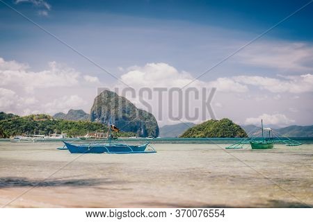 Traditional Banca Boat In Clear Water At Sandy Corong Beach In El Nido, Philippines