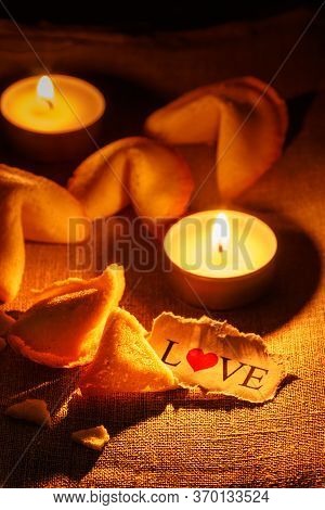 Cookies Shaped Like A Tortellini With The Word Love Written On A Paper And Two Candles Lit.vertical 