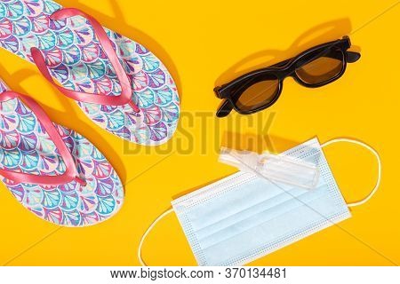 Flat Lay Composition With Summer Vacation Accessories And Face Mask On Yellow Background. Summer Or 