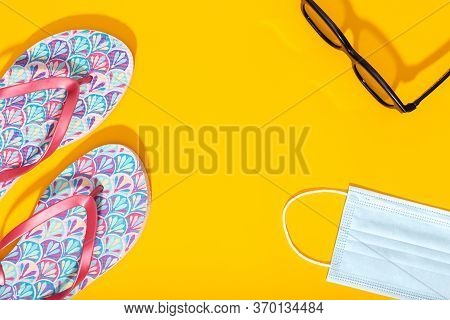 Flat Lay Composition With Summer Vacation Accessories And Face Mask On Yellow Background. Summer Or 