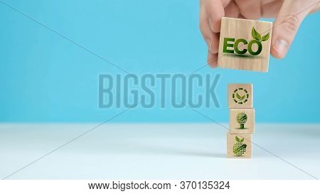 Wooden Blocks With Environmental Symbols Arranged A Man Is Holding The Top One. Ecology