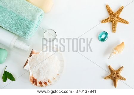 Spa Cosmetics And Towel With Sea Stars And Salt In The Scallop Shell On A White Background On Top