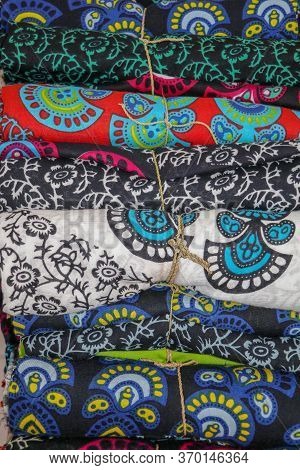 Rolled Up Colored Fabrics Tied With String. Shop With Brightly Colored Sarongs. Sarung Pantai Ready 
